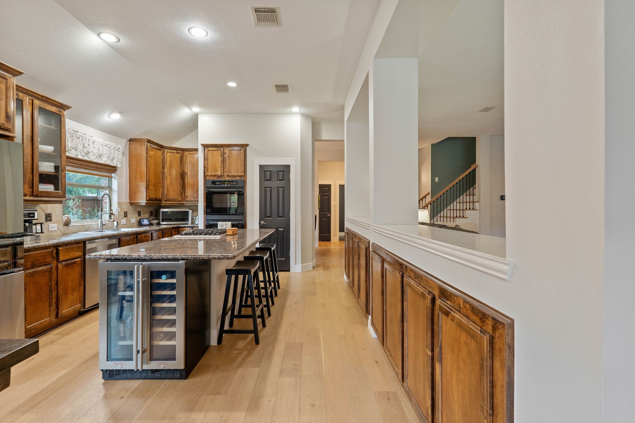 2408 Hollowbrook Lane Conroe, TX 77384 - Photo 14 of 49 This efficient kitchen is outfitted with a wine frig, gas cook top, wall oven, large granite island, lots of cabinet storge and Bonus: built in buffet for those future parties.