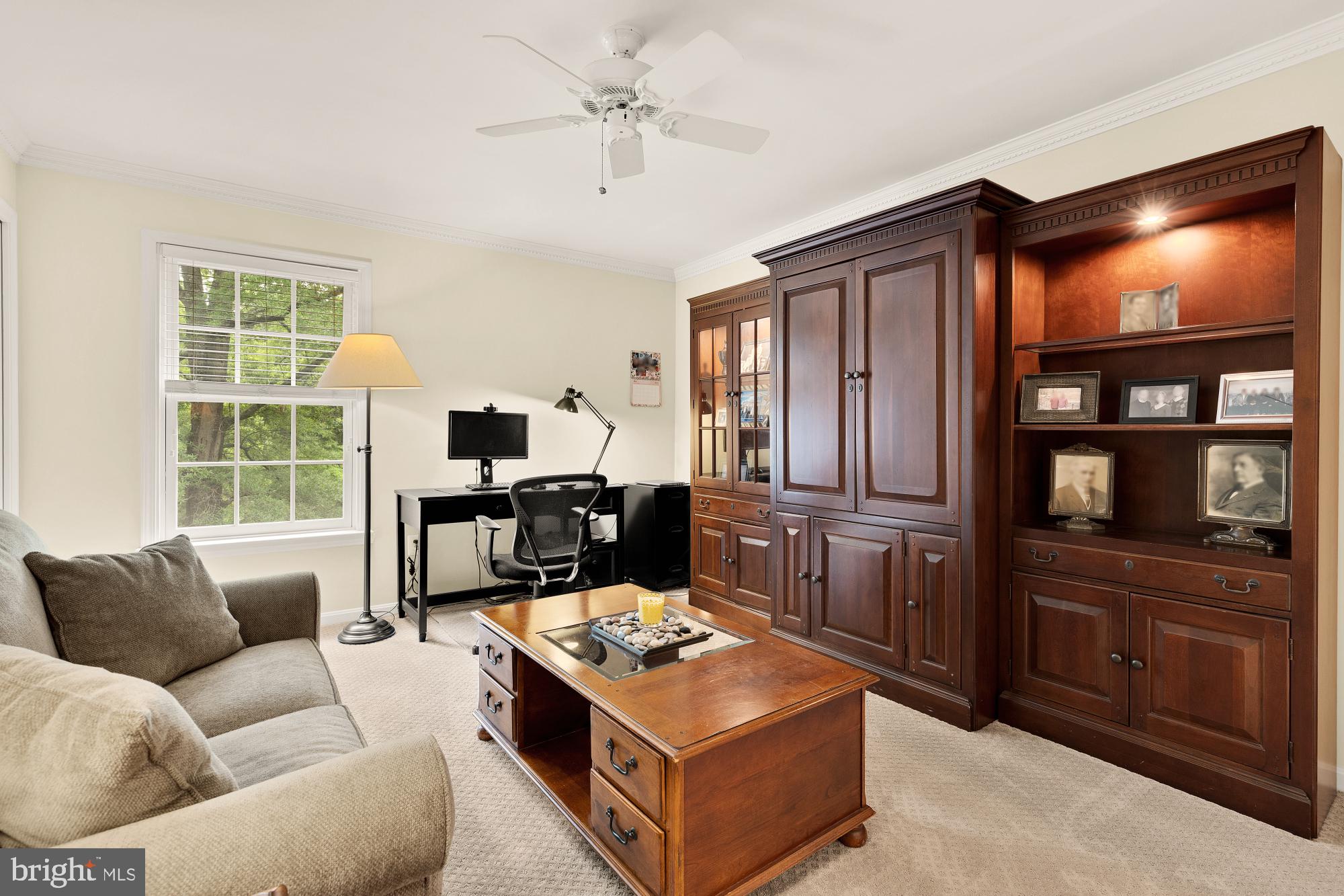 5117 Pheasant Ridge Road Fairfax, VA 22030 - Photo 39 of 59 a living room with furniture a bookshelf and a flat screen tv