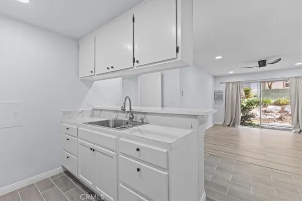 a kitchen with white cabinets and sink