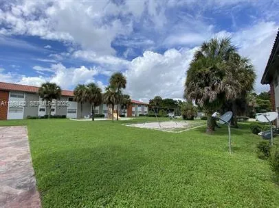 a view of a house with a big yard and a large trees