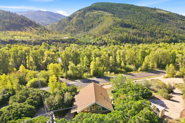 2640 East Weber Canyon Road Oakley, UT 84055 - Photo 3 of 56 Gabled roofline property surrounded by mature trees, with a prominent mountain backdrop