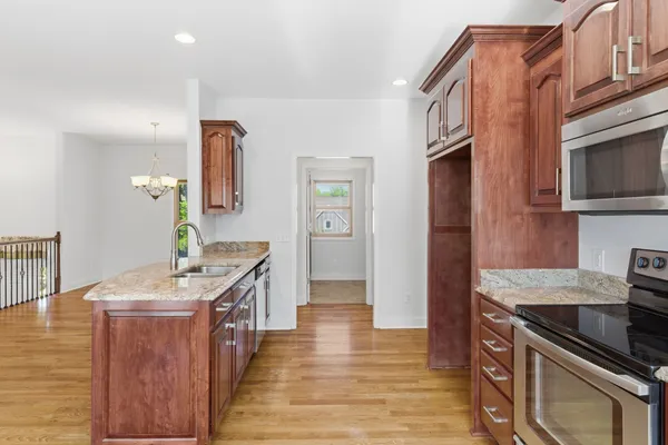 a kitchen with stainless steel appliances granite countertop a sink stove and refrigerator