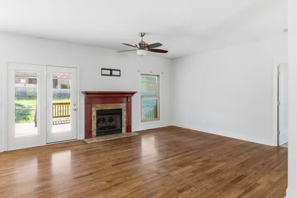 an empty room with windows a fireplace