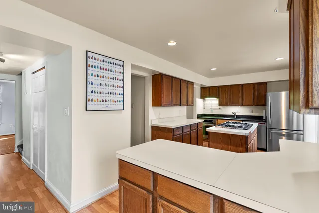 a kitchen with stainless steel appliances a refrigerator and a stove top oven