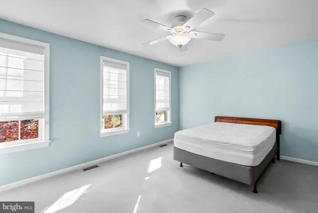 a bed sitting in a bedroom next to a window