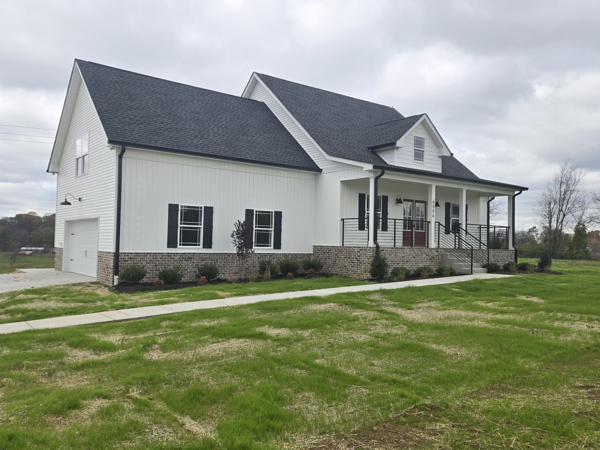 a house that is sitting in the grass with large trees