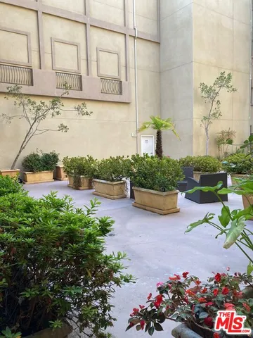 a view of a street with potted plants and a building
