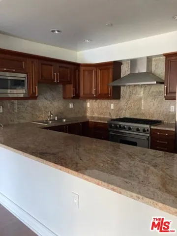 a kitchen with stainless steel appliances granite countertop a sink and a stove
