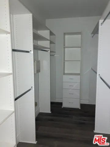 a view of walk in closet with empty racks