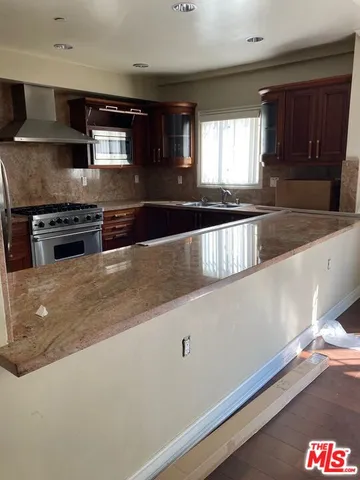 a kitchen with stainless steel appliances granite countertop a sink a stove and a microwave oven