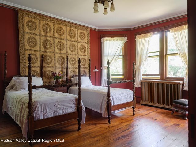 a bedroom with a bed wooden floor and window