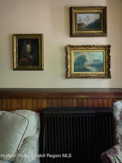 a bedroom with a bed and paintings on the wall