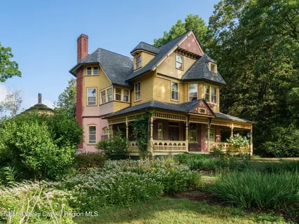 a front view of a house with a yard and potted plants