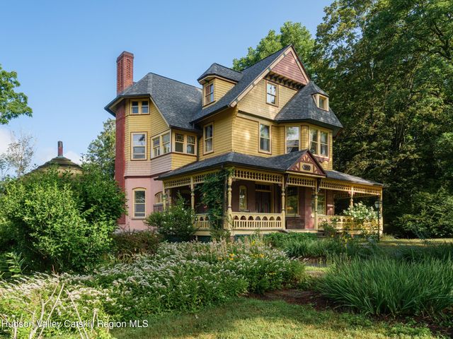 a front view of a house with a yard and potted plants