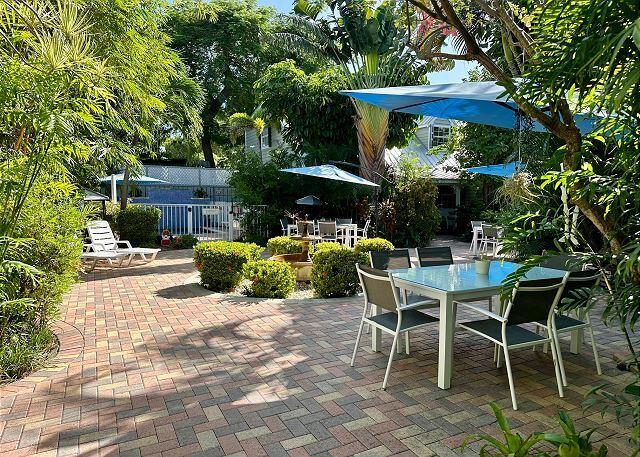 921 Center Street, Unit 12 Key West, FL 33040 - Photo 18 of 22 a view of a patio with furniture and a table and chairs under an umbrella