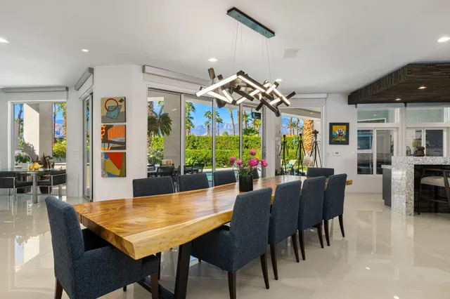 a large dining hall with stainless steel appliances granite countertop a table chairs and a large window