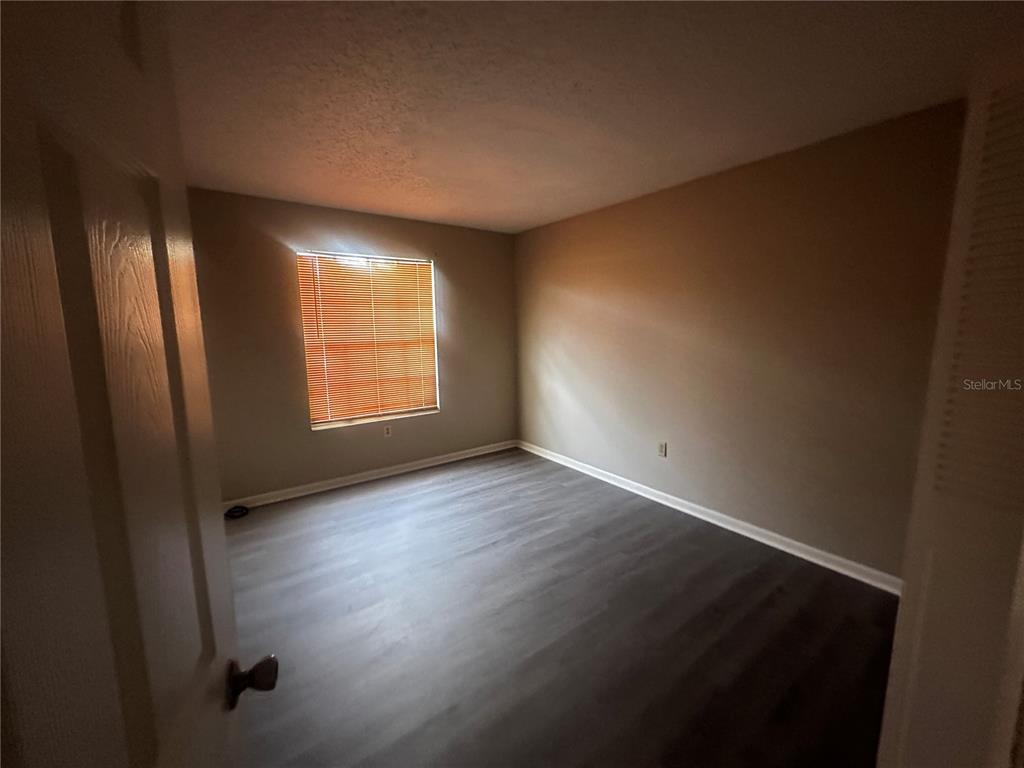 66 Silver Lane Ocala, FL 34472 - Photo 7 of 10 an empty room with wooden floor and windows