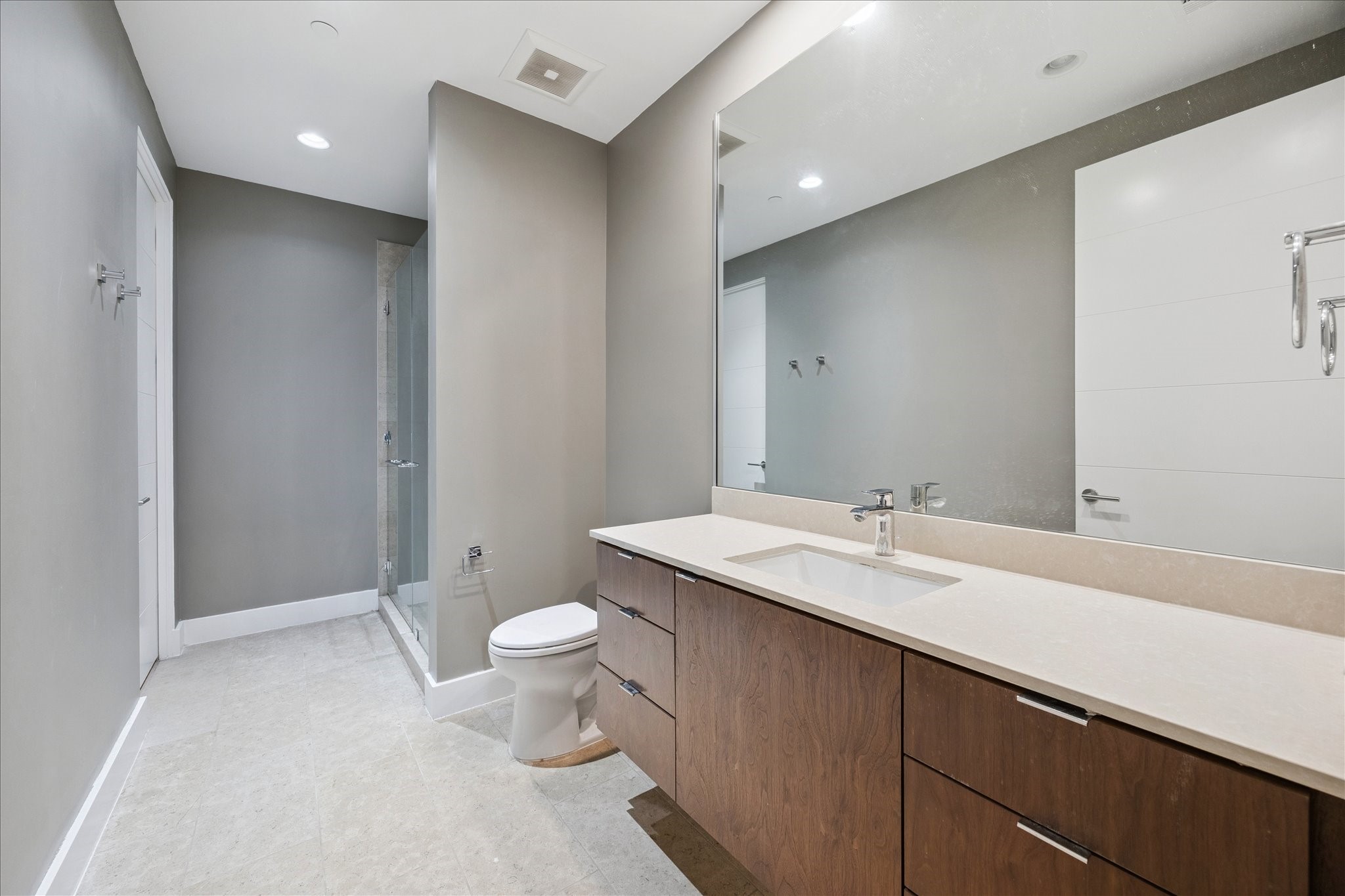 3331 D'Amico Street, Unit 404 Houston, TX 77019 - Photo 17 of 22 a bathroom with a double vanity sink toilet and a mirror