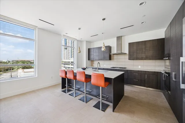 a kitchen with a table chairs refrigerator and microwave
