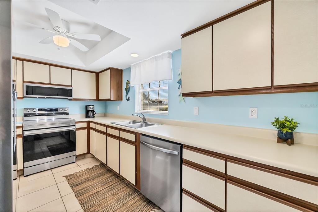 1531 Placida Road, Unit 202 Englewood, FL 34223 - Photo 14 of 44 a kitchen with stainless steel appliances white cabinets and a sink