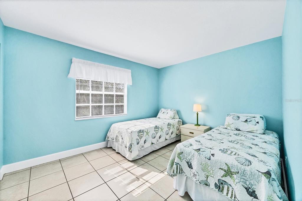 1531 Placida Road, Unit 202 Englewood, FL 34223 - Photo 25 of 44 a bedroom with two beds and a window