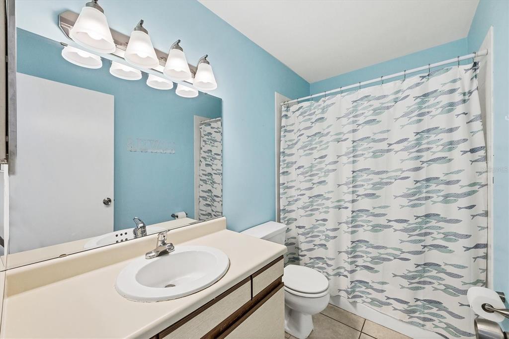 1531 Placida Road, Unit 202 Englewood, FL 34223 - Photo 27 of 44 a bathroom with a sink a toilet and a mirror