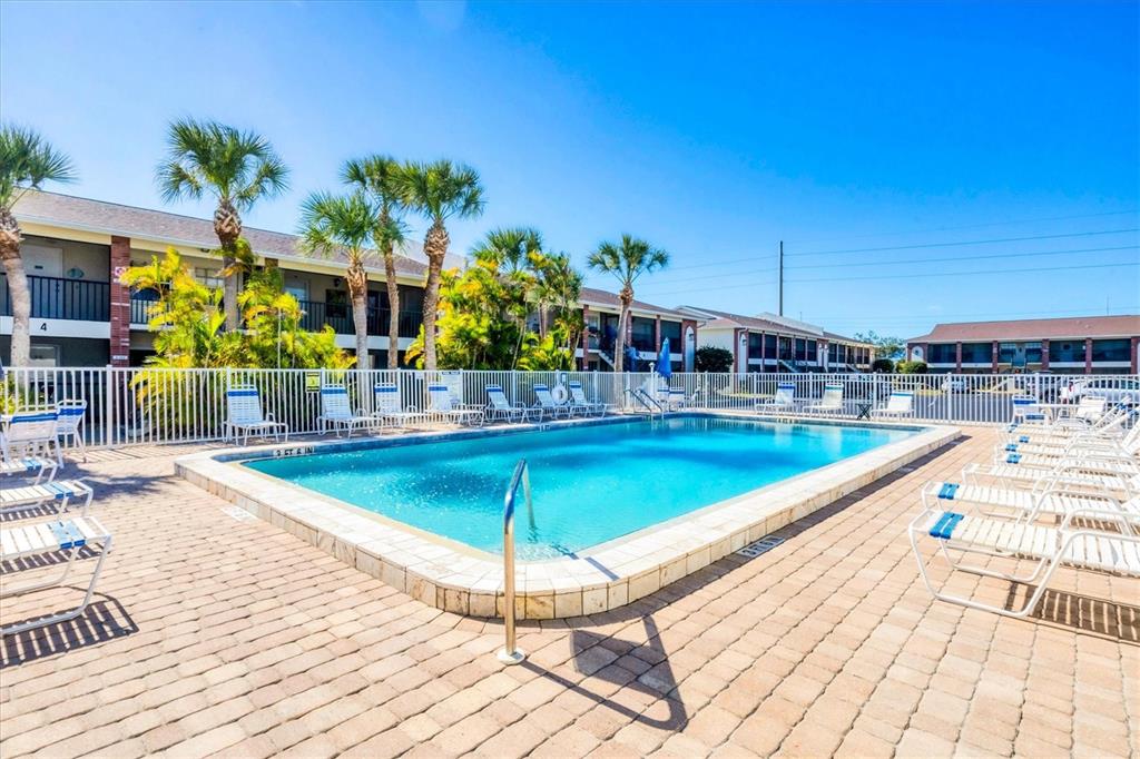 1531 Placida Road, Unit 202 Englewood, FL 34223 - Photo 28 of 44 a view of a swimming pool with a lounge chairs