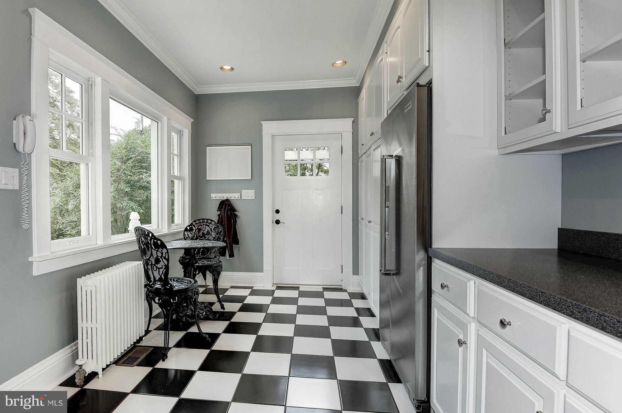 1213 Buchanan Street McLean, VA 22101 - Photo 10 of 30 a kitchen with a black white checkered floor with a dining table and chairs