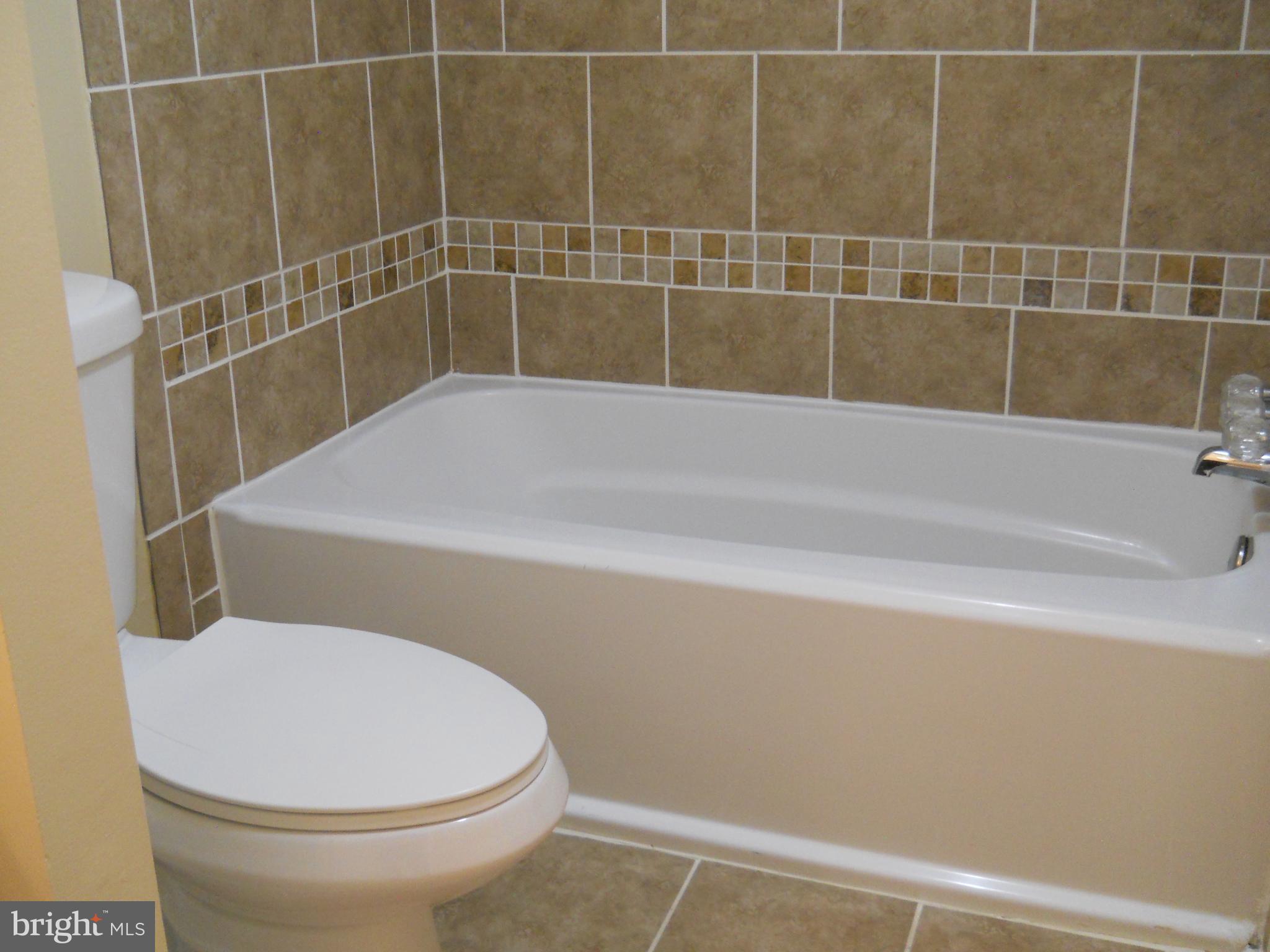 8663 Greenbelt Road, Unit 202 Greenbelt, MD 20770 - Photo 35 of 36 a bathroom with a bathtub and toilet