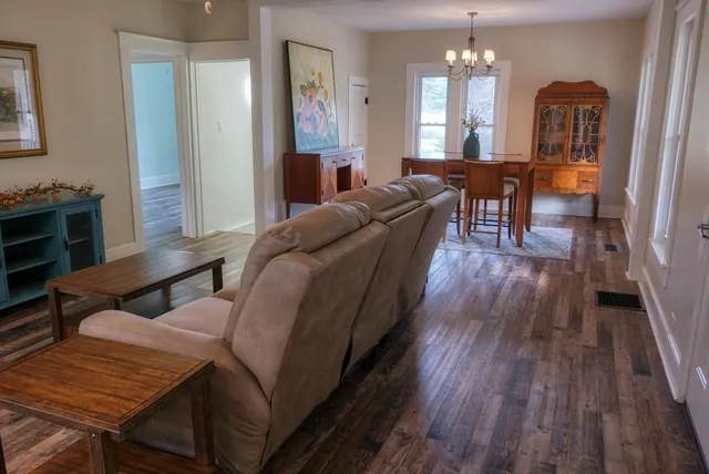 a living room with furniture a fireplace and wooden floor