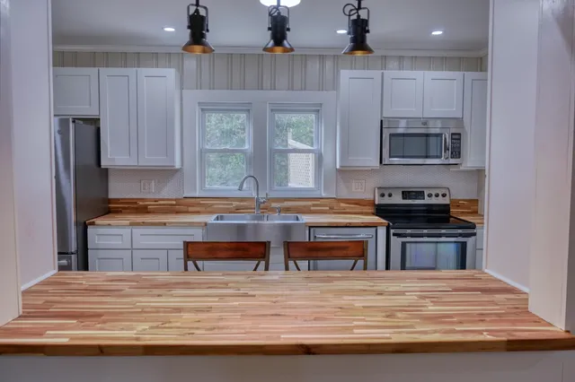 a kitchen with kitchen island granite countertop a stove and a refrigerator