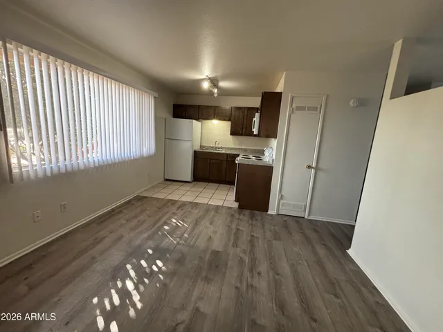 a view of a kitchen with a sink dishwasher cabinets and wooden floor