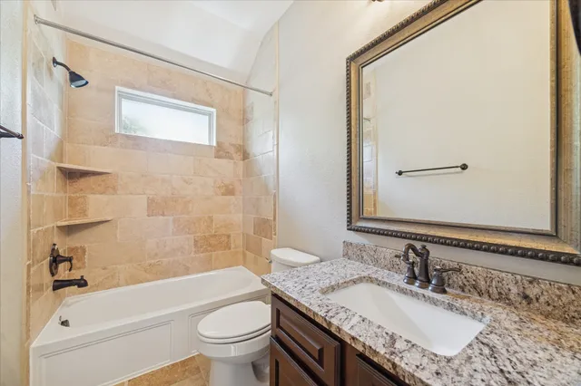 a bathroom with a granite countertop sink toilet and shower