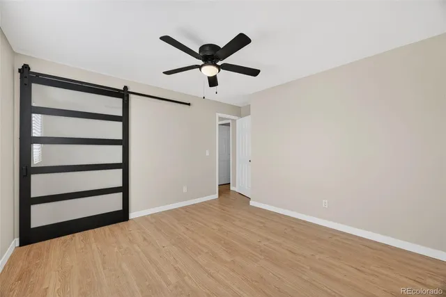 a view of a big room with wooden floor closet ceiling fan and windows