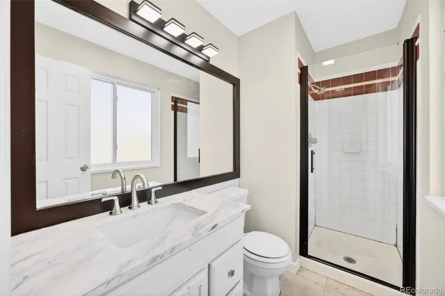 a bathroom with a granite countertop sink toilet and shower