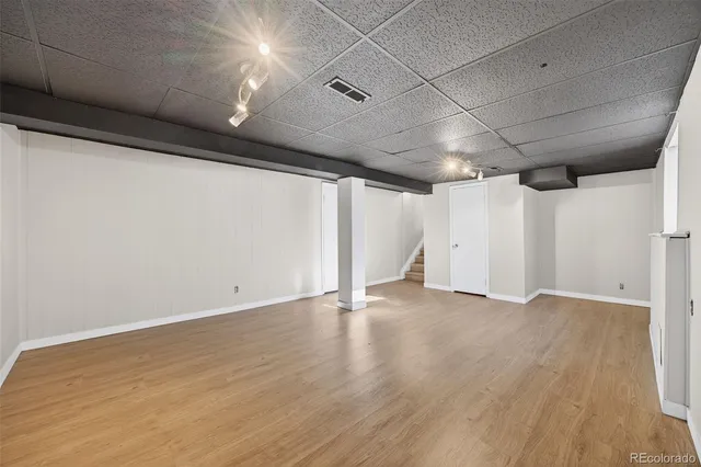 an empty room with wooden floor and white walls