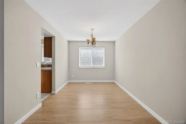 an empty room with windows and a kitchen