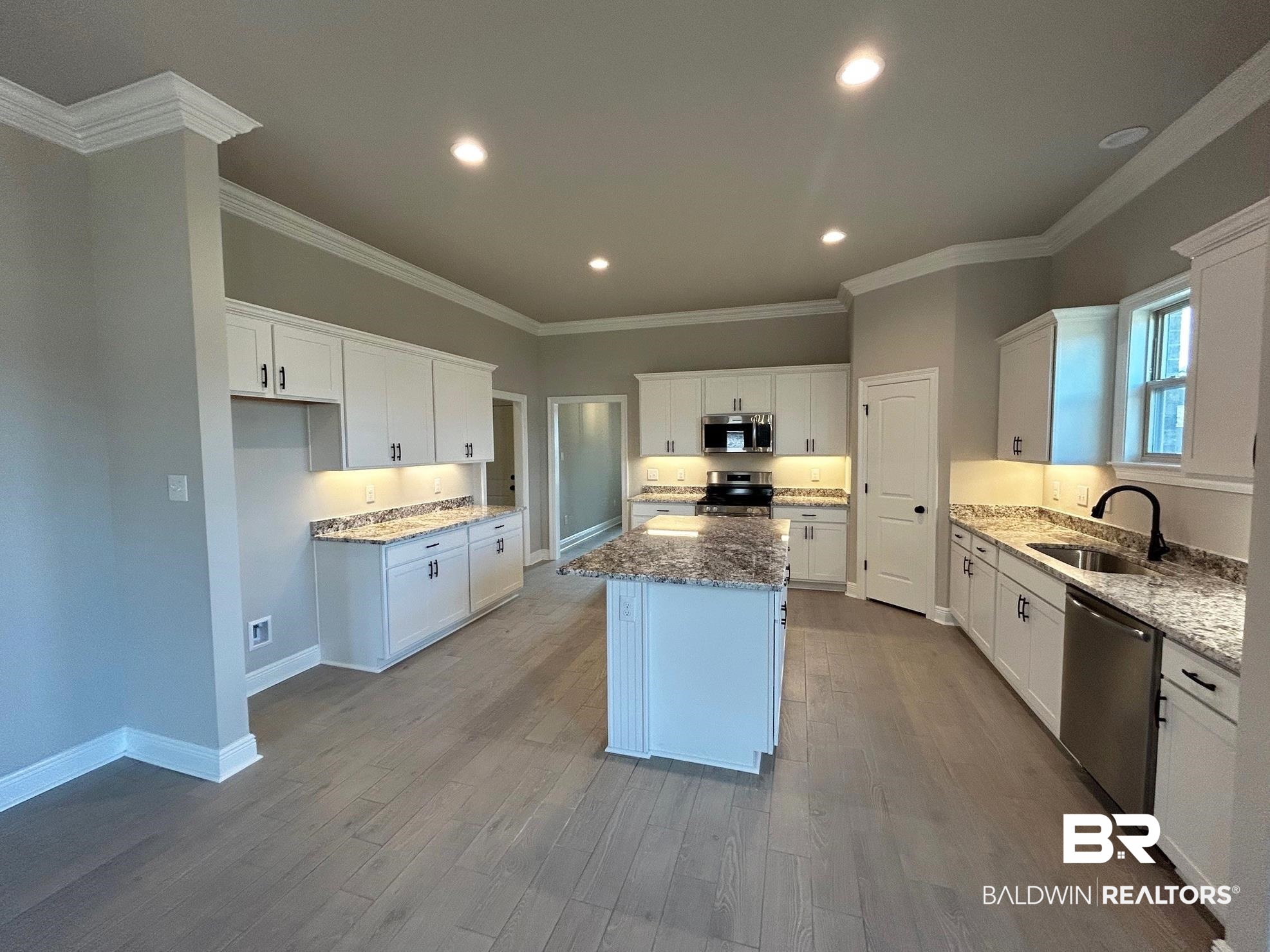 881 Sumter Loop Foley, AL 36535 - Photo 4 of 19 Kitchen with appliances with stainless steel finishes, white cabinetry, a kitchen island, and sink