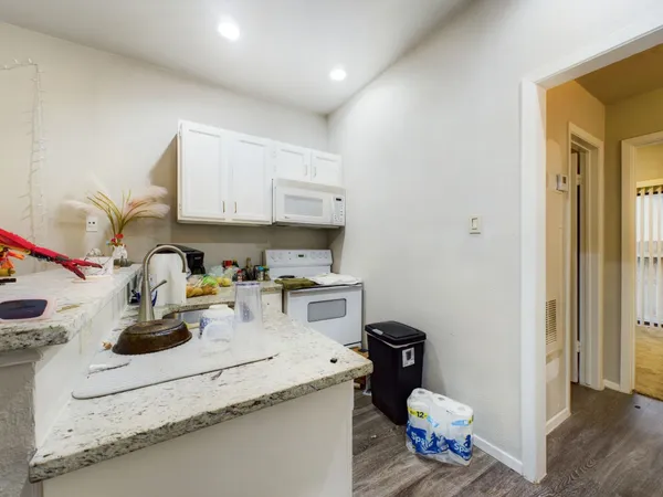 a kitchen with a sink cabinets and wooden floor