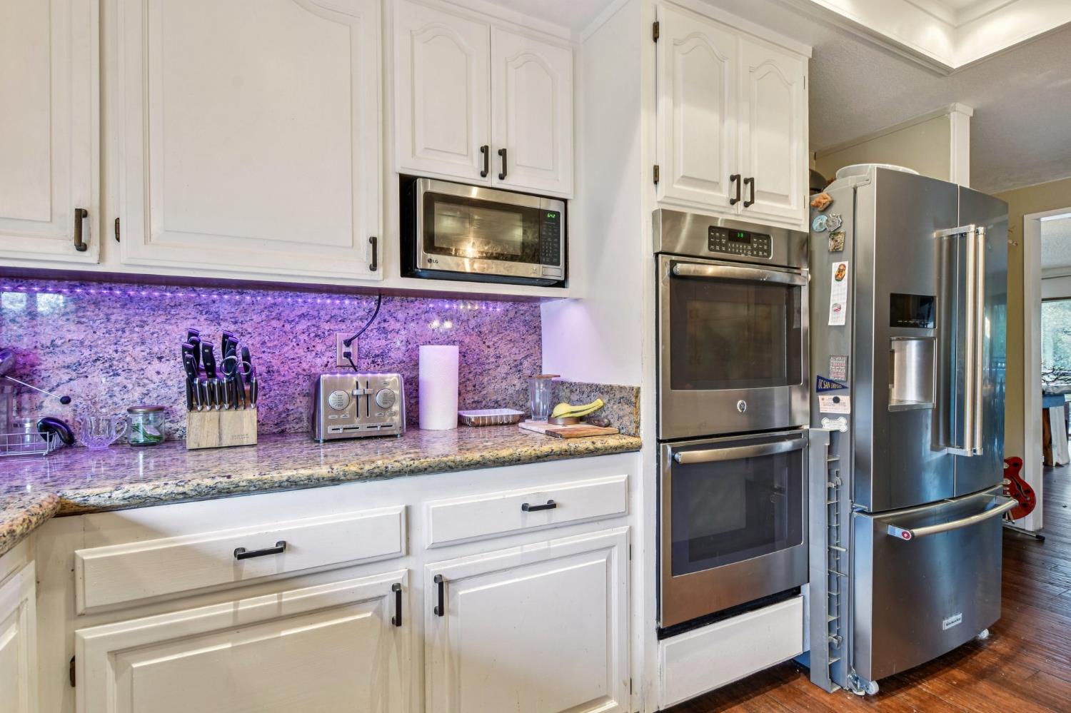 3571 Sudbury Road Cameron Park, CA 95682 - Photo 10 of 87 Kitchen Lights are NOT Purple. Its a refection. Area is bright and warming.Granite Counter with Stainless Steel appliances