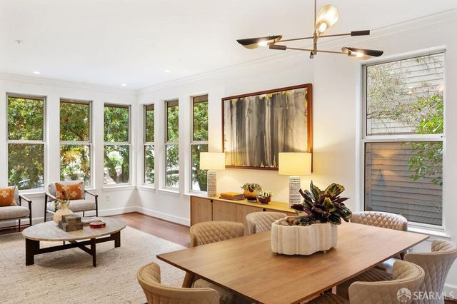 a dining room with furniture a large window and a chandelier