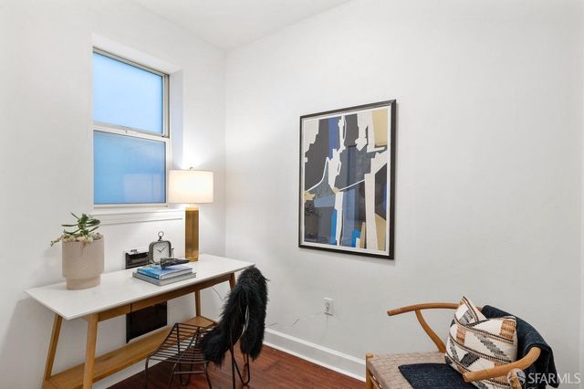 a view of a workspace with furniture and wooden floor