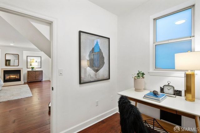a view of a workspace with furniture and wooden floor