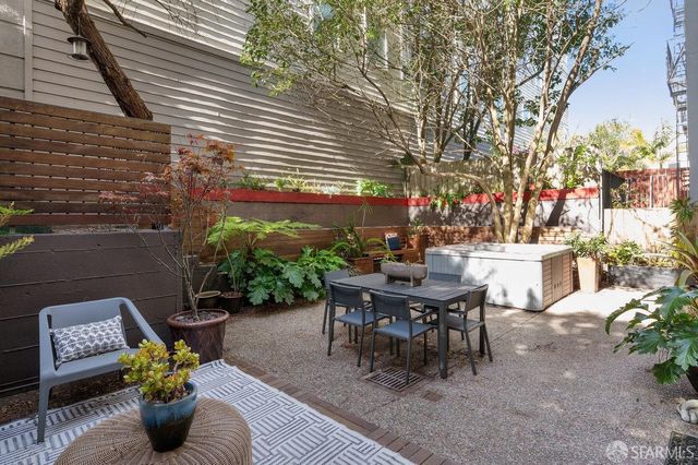 a view of a patio with couches table and chairs and potted plants