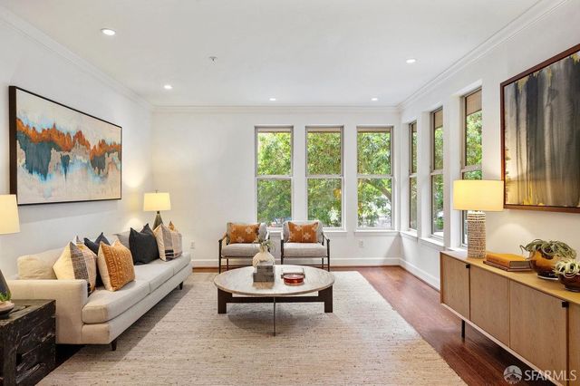 a living room with furniture and large windows