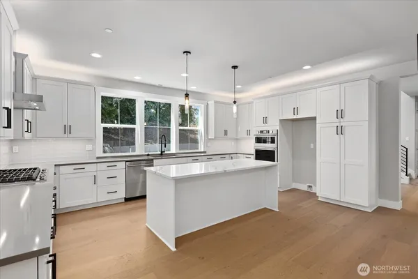 a large kitchen with kitchen island a sink stainless steel appliances and cabinets