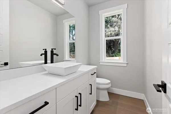 a bathroom with a sink toilet and window
