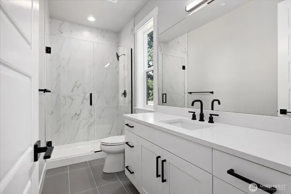 a bathroom with a double vanity sink toilet and shower