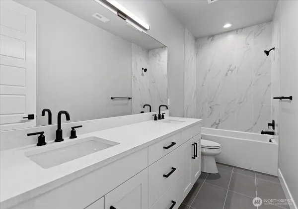 a bathroom with a double vanity sink mirror bathtub and toilet