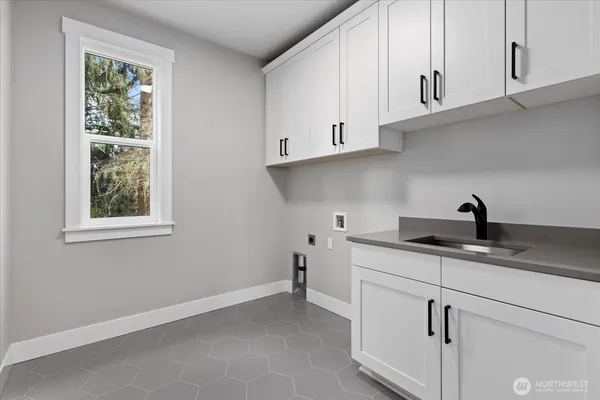 a kitchen with stainless steel appliances granite countertop white cabinets and a window